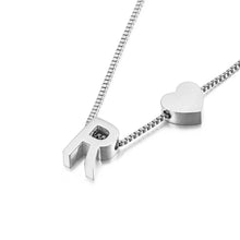 Cargar imagen en el visor de la galería, La Pulsera de tobillo con inicial en color plateado presenta un dije con la letra R y un pequeño corazón, ambos en una delicada cadena de eslabones cuadrados, mostrados sobre fondo blanco.