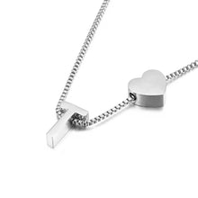 Cargar imagen en el visor de la galería, Un collar de plata con colgantes de cruz y corazón en una cadena de caja, estilizados juntos-ideal para combinar con tu pulsera de tobillo con inicial plateado para un look coordinado.