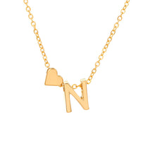 Cargar imagen en el visor de la galería, Un collar dorado con una delicada cadena, con una letra N y un pequeño charm de corazón, perfecto para combinar con la Pulsera de tobillo con inicial en dorado para un look elegante y coordinado.