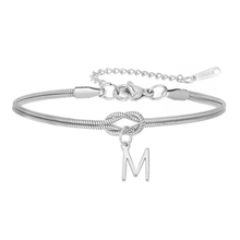 Cargar imagen en el visor de la galería, La Pulsera de nudo con inicial es de plata, con diseño de cadena serpiente, nudo central y charm colgante con letra M. Tiene cierre de langosta y cadena ajustable, perfecta como pulsera personalizada y un regalo inolvidable.