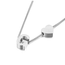 Cargar imagen en el visor de la galería, Pulsera de tobillo con inicial en color plateado, con un dije de letra G mayúscula y un dije en forma de corazón juntos sobre una cadena tipo box, inspirada en el estilo personalizado, mostrada sobre fondo blanco.