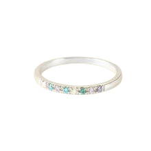 Cargar imagen en el visor de la galería, Un fino y plateado Anillo con piedras de nacimiento personalizado con una hilera de pequeñas gemas multicolores engarzadas a lo largo de la mitad superior, sobre un fondo blanco liso.