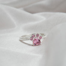 Cargar imagen en el visor de la galería, Anillo Patita rosa en plata con un diseño de patita y gemas rosas, presentado sobre tela blanca suave-el regalo ideal para amantes de mascotas.
