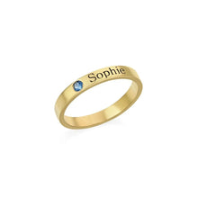 Cargar imagen en el visor de la galería, Anillos apilables con nombres y piedras de nacimiento: un anillo personalizado de oro con una gema azul pequeña y el nombre Sophie grabado en la banda, mostrado sobre fondo blanco.