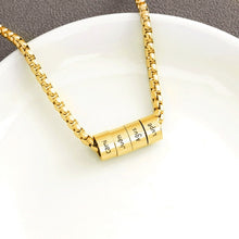 Cargar imagen en el visor de la galería, El Collar de cadena con dijes personalizados en oro incluye un dije cilíndrico grabado con los nombres Coni, Juan, Agus y Lupe. Perfecto para regalar en el Día del Padre. Se muestra sobre un plato blanco con fondo gris.
