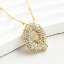 Cargar imagen en el visor de la galería, Collar Inicial Bubble - ¡Llévate 2 por el precio de 1! Un collar dorado con inicial Q y cristales brillantes sobre fondo blanco, ideal como collar personalizado o regalo especial.