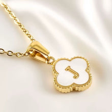 Cargar imagen en el visor de la galería, Consigue el Collar Trébol con inicial: colgante trébol con centro esmaltado blanco y la letra J, presentado sobre satén blanco. ¡Llévate 2 por el precio de 1!.