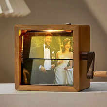 Cargar imagen en el visor de la galería, El Marco fotográfico con manivela ilumina una foto de boda de una pareja sonriente y elegante, brindando juntos; es el regalo conmemorativo perfecto.