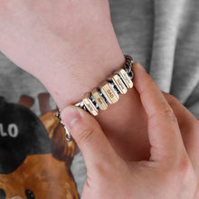 Cargar imagen en el visor de la galería, Una persona se ajusta una pulsera de cadena personalizada en la muñeca, con cuentas de metal grabadas con nombres como DAD, SOPHIA y ANDREW. Llevan una camisa gris con un animal de dibujos animados: un regalo ideal para padre.
