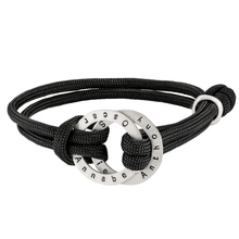 Cargar imagen en el visor de la galería, La Pulsera de cuerda para hombre grabada tiene un cordón negro y un colgante circular de plata grabado con los nombres Annabe, Oscar y Antony. El colgante está entretejido en el cordón con un nudo lateral, perfecto como regalo para hombre.