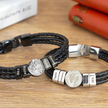 Cargar imagen en el visor de la galería, Dos pulseras de cuero con nombres y foto, ideales como pulsera personalizada para hombre, llevan grabados personalizados en cuentas de metal. Presentadas sobre madera junto a dos libretas naranjas, son un regalo original para hombre.