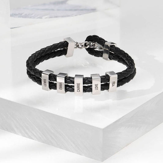 La Pulsera de cuero para Papá en color negro cuenta con seis cuentas rectangulares plateadas grabadas con los nombres LEWIS, EMMA, CARRIE, I, LOVE y YOU. Es el regalo perfecto para hombre.