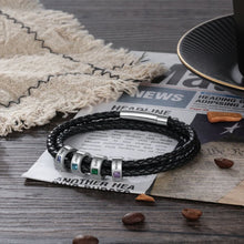 Cargar imagen en el visor de la galería, La Pulsera Piedras de vida - A mi Padre, una pulsera de cuero trenzado negro con cinco cuentas de plata y piedras preciosas vibrantes, se sienta en un periódico por los granos de café-haciéndolo el regalo perfecto Día del Padre.