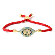 Cargar imagen en el visor de la galería, La Pulsera protectora de ojo turco es una pulsera roja con dije de ojo turco en oro y turquesa, decorada con piedras azules y blancas y detalles dorados; combina estilo y protección en un solo accesorio.