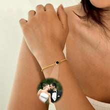 Cargar imagen en el visor de la galería, Una mujer luce la Pulsera Recuerdo eterno, un delicado proyector de fotos con piedra negra. Un recuadro muestra a una pareja besándose, haciendo de este accesorio un regalo personalizado y especial.