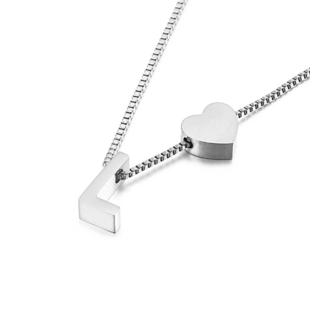 Primer plano de un collar de plata con colgantes de corazón y una L angular sobre una brillante cadena de eslabones cuadrados: un elegante complemento para el Plateado Pulsera de tobillo con inicial.