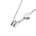 Un collar de cadena de caja de plata con un charm de corazón y dos colgantes M combina a la perfección con la pulsera de tobillo con inicial plateado para un look coordinado.