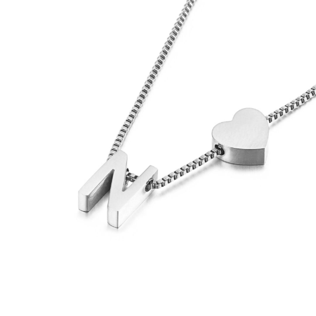 Un collar de cadena de caja de plata con una letra N mayúscula y un charm de corazón combina a la perfección con el Pulsera de tobillo plateado con inicial para un look coordinado.