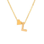 Un collar dorado con una delicada cadena que incluye dos charms -un pequeño corazón y la letra L- ambos en dorado, uno al lado del otro. Combínalo con la Pulsera de tobillo con inicial en color dorado para un look coordinado y elegante. El fondo es blanco liso.