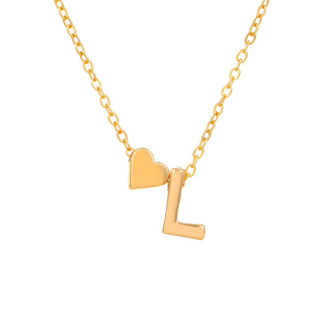 Un collar dorado con una delicada cadena que incluye dos charms -un pequeño corazón y la letra L- ambos en dorado, uno al lado del otro. Combínalo con la Pulsera de tobillo con inicial en color dorado para un look coordinado y elegante. El fondo es blanco liso.