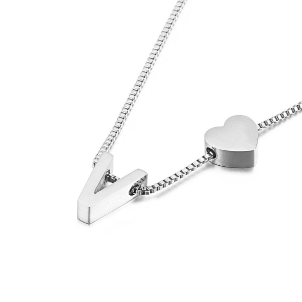 Un collar de cadena de caja de plata con una letra V mayúscula y un pequeño charm de corazón, perfecto para combinar con tu Pulsera de tobillo con color inicial plateado.