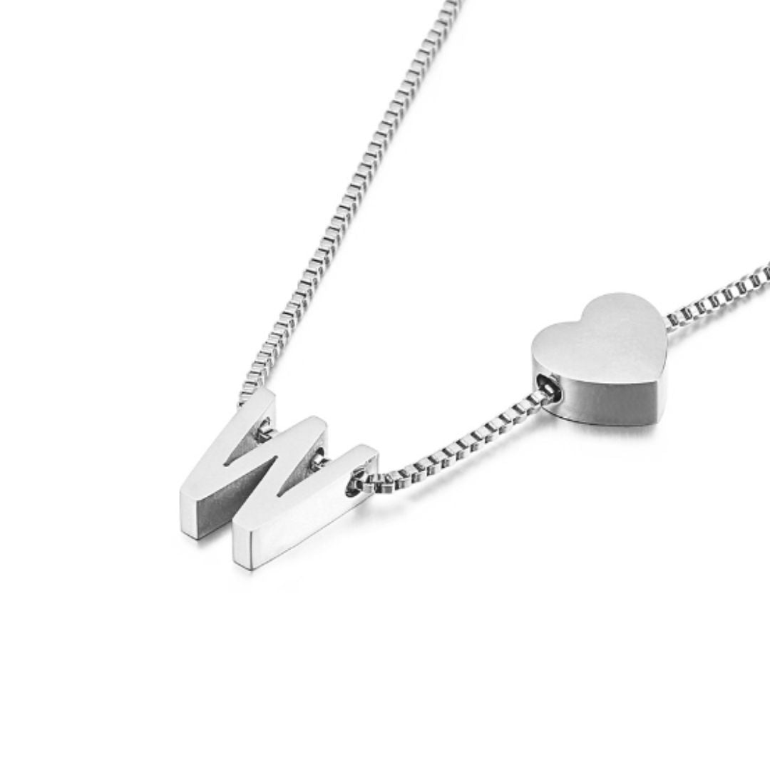 Un collar plateado de cadena de caja con una letra W metálica y un charm de corazón combina a la perfección con nuestro Pulsera de tobillo plateado con inicial para un look coordinado y lleno de significado.