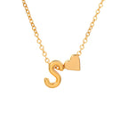 Un collar de cadena dorada con una letra S dorada y un charm de corazón, sobre fondo blanco, combina a la perfección con nuestra pulsera de tobillo con inicial dorada para un look coordinado.