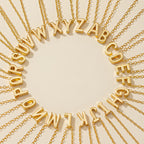Pulsera de tobillo con inicial: Elegantes pulseras de tobillo doradas con colgantes del alfabeto dispuestos en círculo sobre beige, cada cadena irradiando hacia el exterior, perfectas para exhibir tu estilo único.