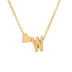 Un collar de oro con una fina cadena tiene un colgante en forma de W y un pequeño dije de corazón a la izquierda, perfecto para combinar con la Pulsera de tobillo con inicial en dorado. El fondo es blanco liso.