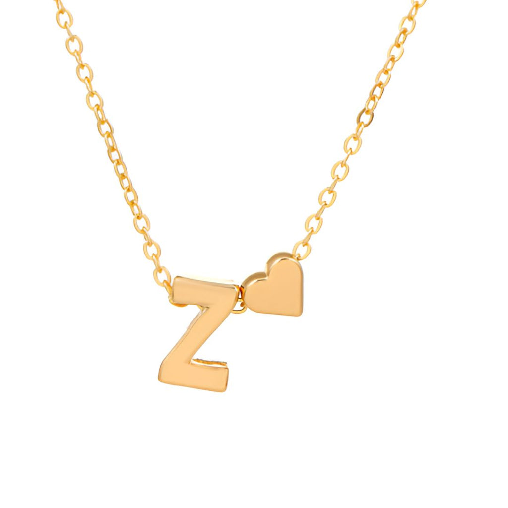 Un collar dorado con una letra Z y un charm de corazón en una delicada cadena, sobre un fondo blanco, perfecto para combinar con tu Pulsera de tobillo con inicial en dorado para un look elegante y coordinado.