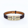 Pulsera de cuero personalizada con nombres en dorado, lleva siete placas grabadas (Betty, Jackson, Olivia, DAD, David, Blanche, Lewis) separadas por gemas. Un regalo único para papá.