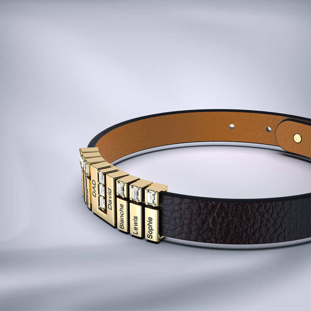 La Pulsera de cuero personalizada con nombres es marrón, tiene dijes rectangulares dorados grabados con nombres diferentes y algunos decorados con piedras claras; una opción única para regalar a papá.