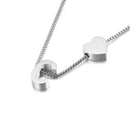 Un collar de plata con cadena de caja y dos colgantes -un corazón y la letra C- combina a la perfección con la Pulsera de tobillo con inicial en plateado para un look coordinado.
