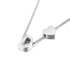 Un plateado "Pulsera de tobillo con inicial" luce una delicada cadena con un charm de letra D en bloque y un charm en forma de corazón uno al lado del otro, a modo de tobillera con inicial, sobre un fondo blanco.