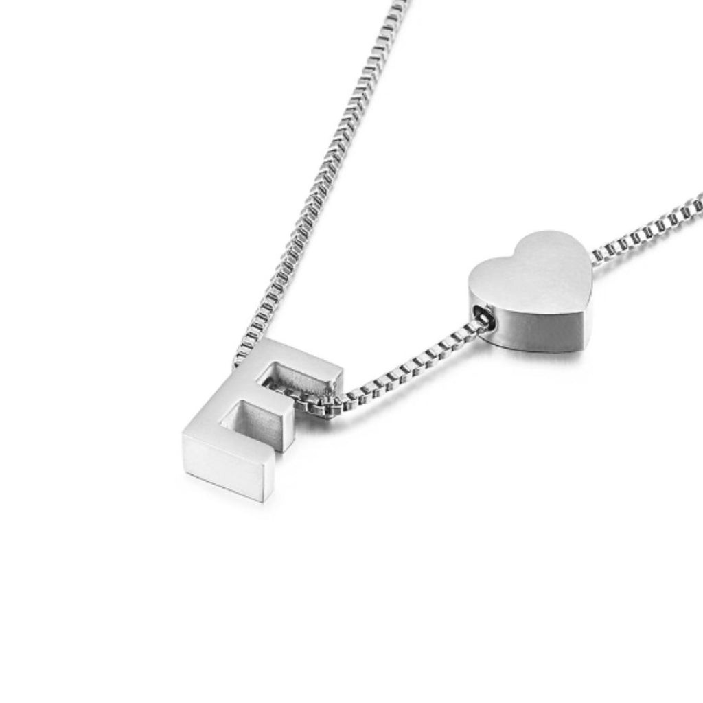 Un collar de cadena de caja de plata con una letra F en bloque y un charm de corazón, sobre un fondo blanco, ideal para combinar con la Pulsera de tobillo con inicial para un look coordinado.
