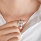Una persona con camisa blanca sostiene el collar "A mi esposa" - Collar corazón para siempre, con una gema central brillante y pequeñas piedras a lo largo del contorno del corazón, cerca de su clavícula-el regalo perfecto para pareja.
