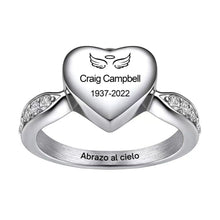 Cargar imagen en el visor de la galería, El Anillo Abrazo al cielo personalizado es un anillo de corazón de plata grabado con alas de ángel, un halo, &quot;Craig Campbell 1937-2022&quot; y &quot;Abrazo al cielo&quot; en el interior de la banda, con pequeños detalles de diamantes a cada lado.