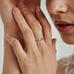 Primer plano de la mano de una persona que lleva el Anillo corazón del bosque con una banda de plata en el dedo; también se ven sus labios y parte de su cara.