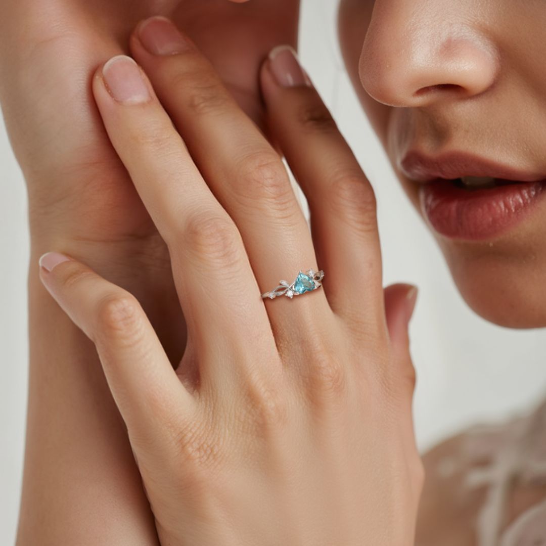 Primer plano de la mano de una persona que lleva el Anillo corazón del bosque con una banda de plata en el dedo; también se ven sus labios y parte de su cara.
