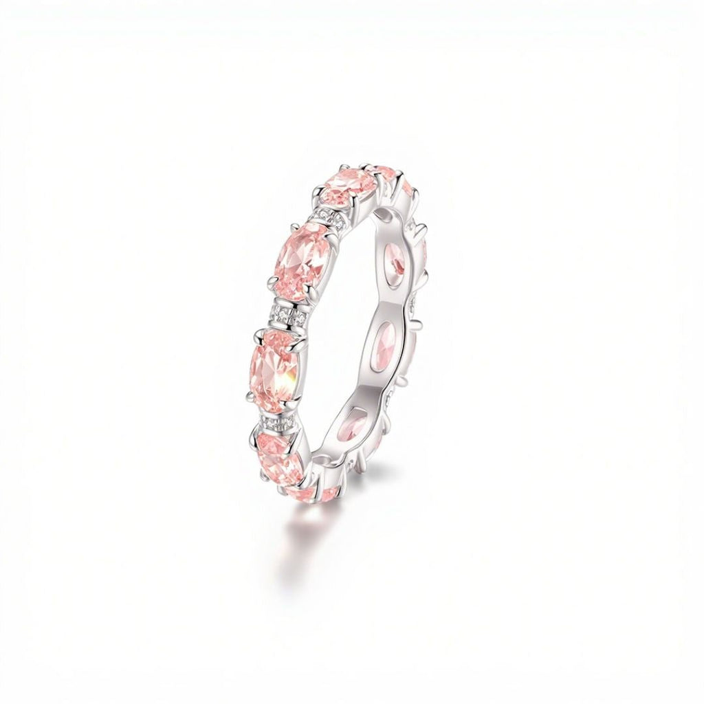 El Anillo Energía Zodiacal con piedra de nacimiento es un anillo de plata con múltiples piedras energéticas rosas de talla oval engastadas en un patrón continuo, sobre fondo blanco.
