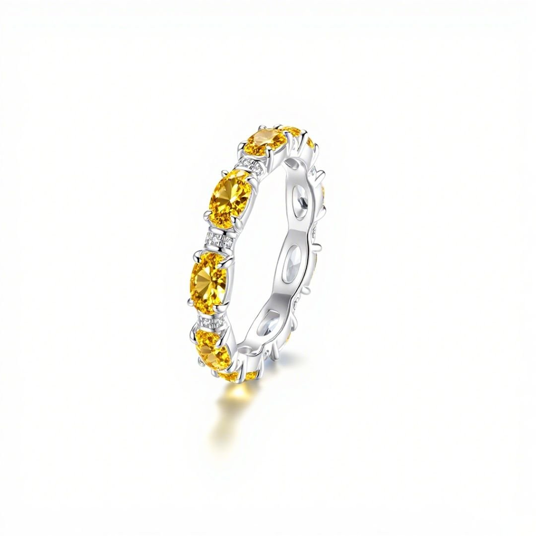 El Anillo Energía Zodiacal con piedra de nacimiento es un anillo de plata con gemas amarillas de talla ovalada engarzadas en garras, inspirado en la joyería espiritual y el poder de las piedras energéticas, que se muestra sobre un fondo blanco.