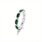 Anillo Energía Zodiacal con piedra de nacimiento: un anillo de plata con varias piedras energéticas verdes ovaladas engastadas en banda continua, expuesto sobre fondo blanco con sombra suave.