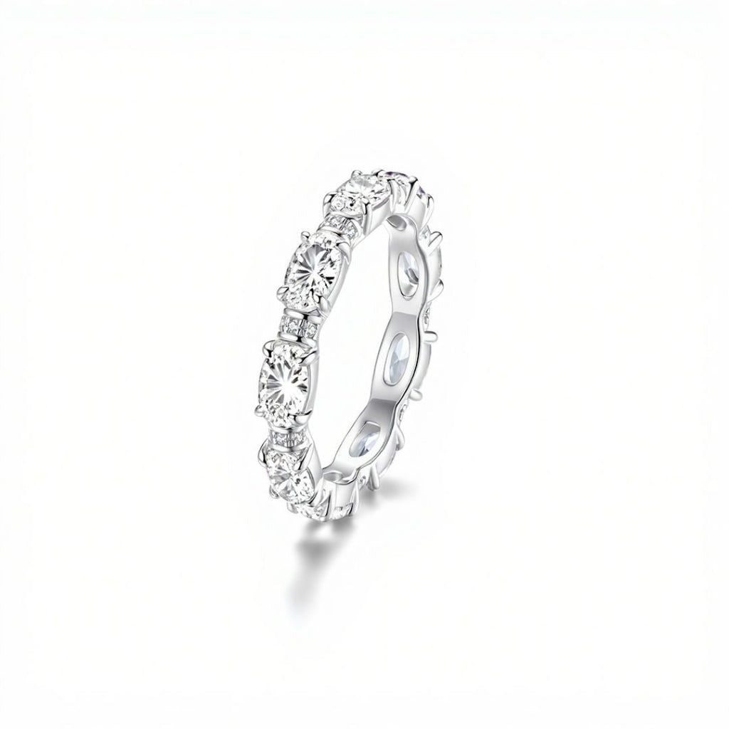 El Anillo Energía Zodiacal con piedra de nacimiento es ideal para los amantes de la joyería espiritual y las piedras energéticas, ya que presenta una banda continua de piedras redondas engastadas en garras sobre un fondo blanco liso.