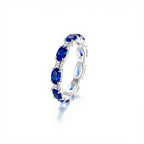 Anillo Energía Zodiacal con piedra de nacimiento, un anillo plateado con grandes gemas azul profundo ovaladas, valorado en joyería espiritual por su conexión con los signos zodiacales, exhibido sobre fondo blanco.