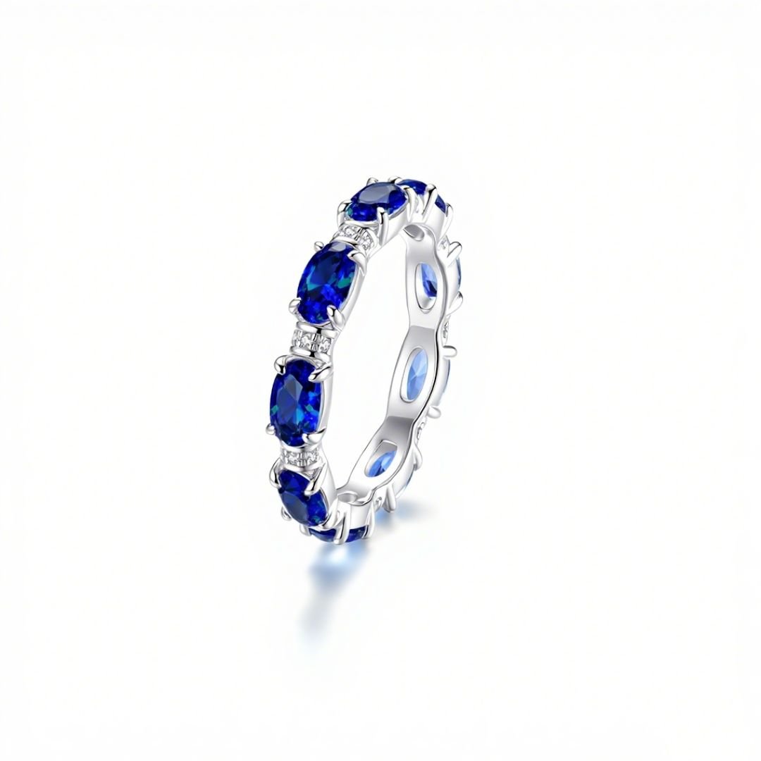 Anillo Energía Zodiacal con piedra de nacimiento, un anillo plateado con grandes gemas azul profundo ovaladas, valorado en joyería espiritual por su conexión con los signos zodiacales, exhibido sobre fondo blanco.