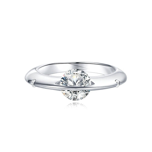 Anillo giratorio estelar: un anillo de plata ajustable con un diamante redondo sujeto por dos delicadas garras, que le dan un efecto flotante, sobre fondo blanco.