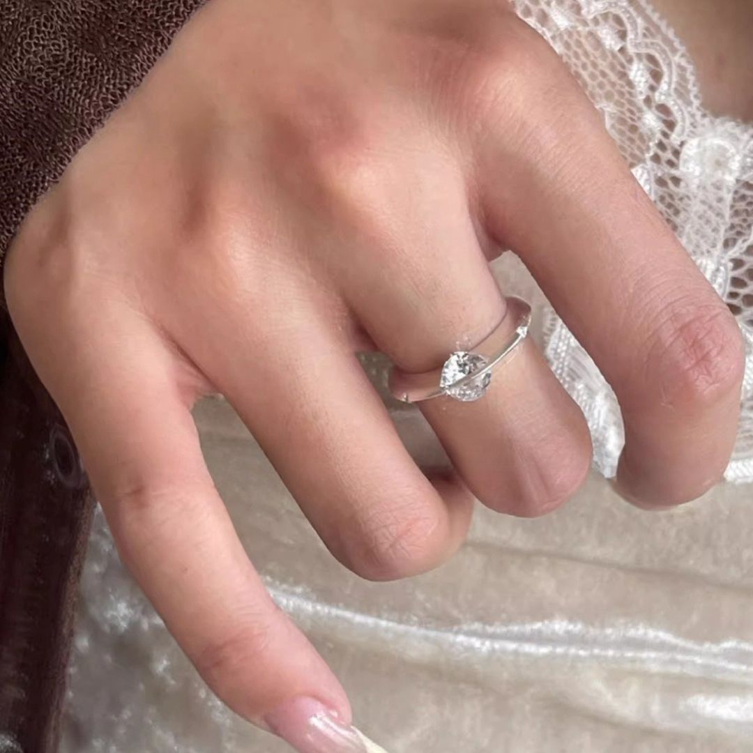 Una mano lleva el Anillo giratorio estelar, un anillo giratorio de acero quirúrgico blanco.