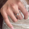 Una mano lleva el Anillo giratorio estelar, un anillo giratorio de acero quirúrgico blanco.