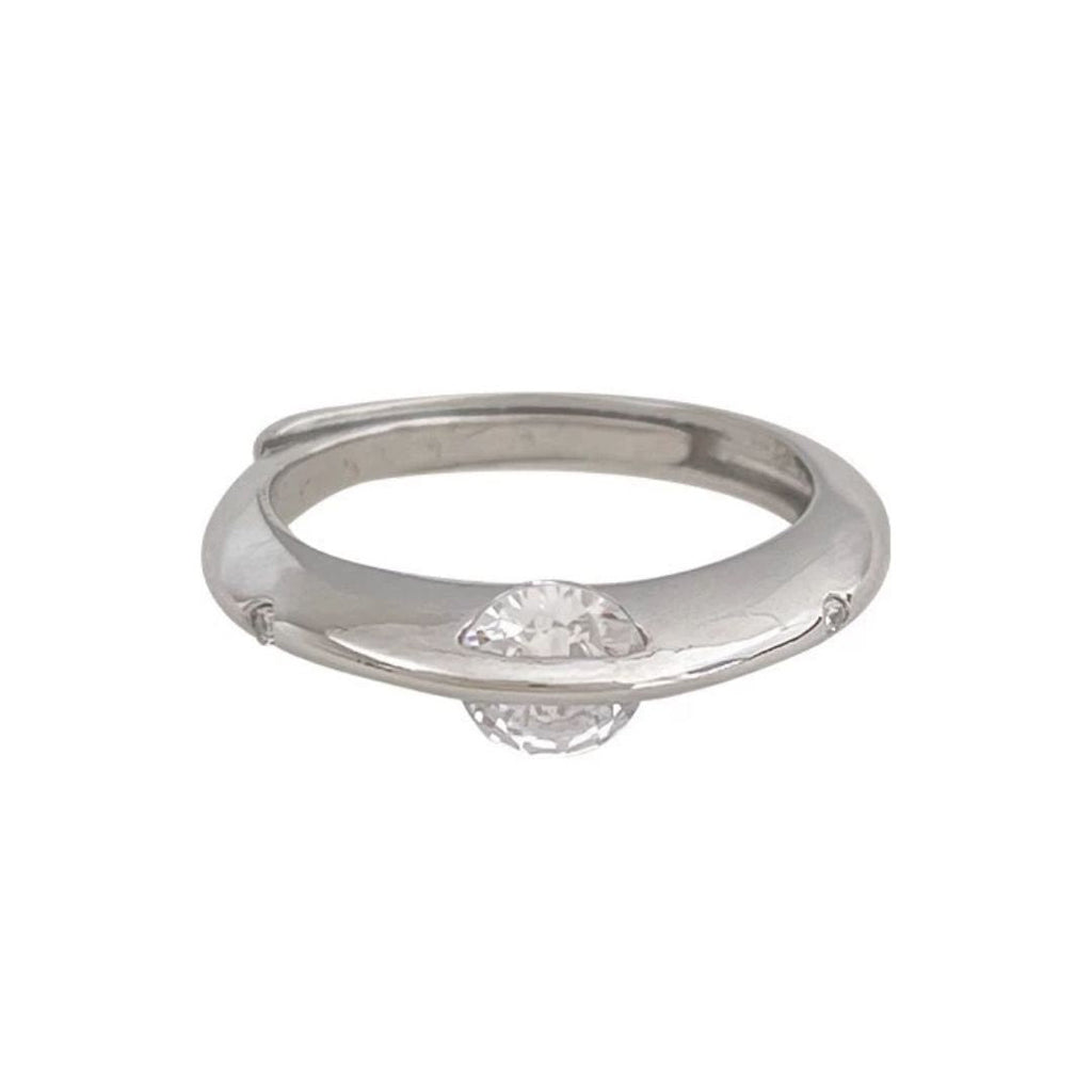 El Anillo giratorio estelar es un anillo de plata moderno y minimalista con una única gema transparente de talla redonda engastada en la banda y parcialmente rodeada de elegante acero quirúrgico blanco.