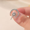 Una mano sostiene un Anillo Luna creciente, de acero inoxidable ajustable, con diseño de sol y luna decorado con gemas claras que representan la fuerza femenina.